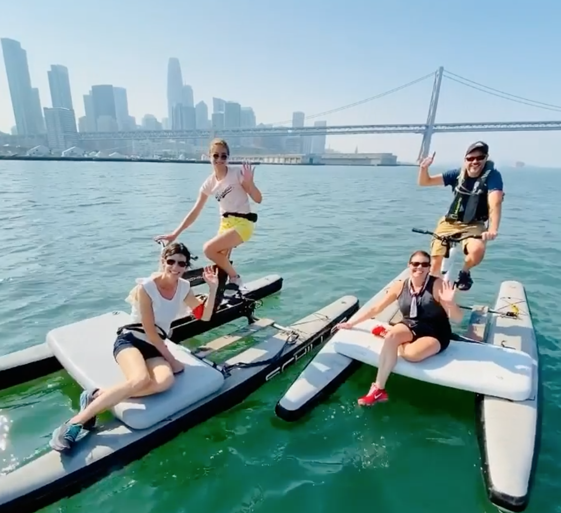 People water biking near the Bay Bridge, photo credit to SpinOut Fitness