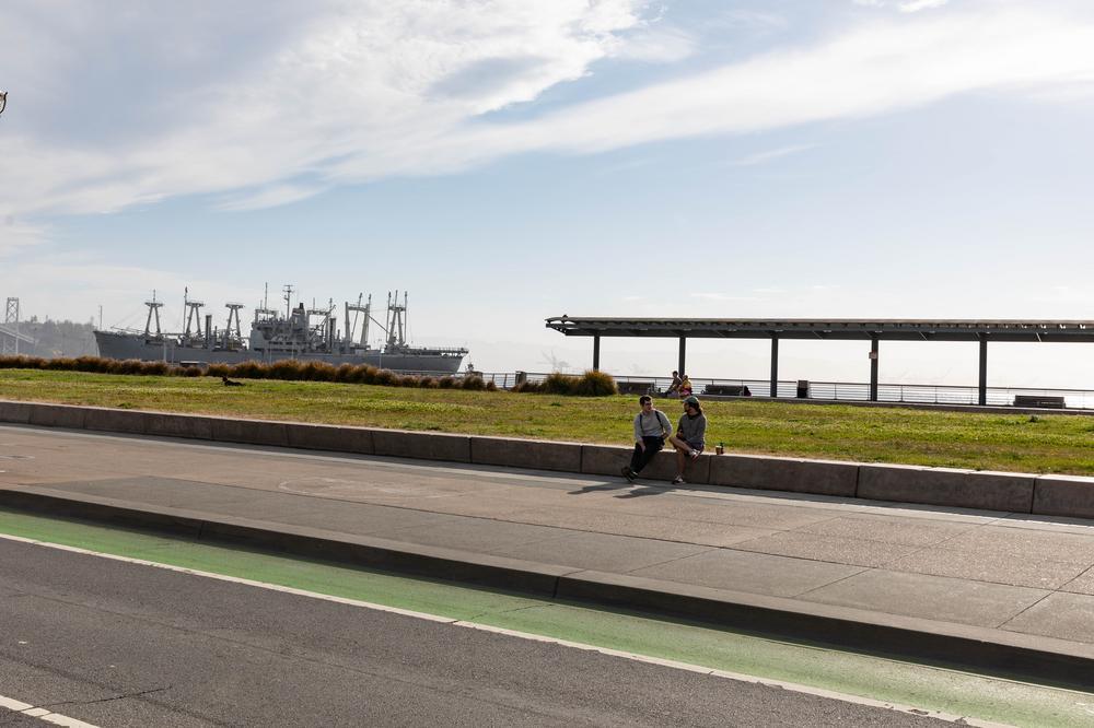 People rest by the lawn at Brannan Street Wharf Park