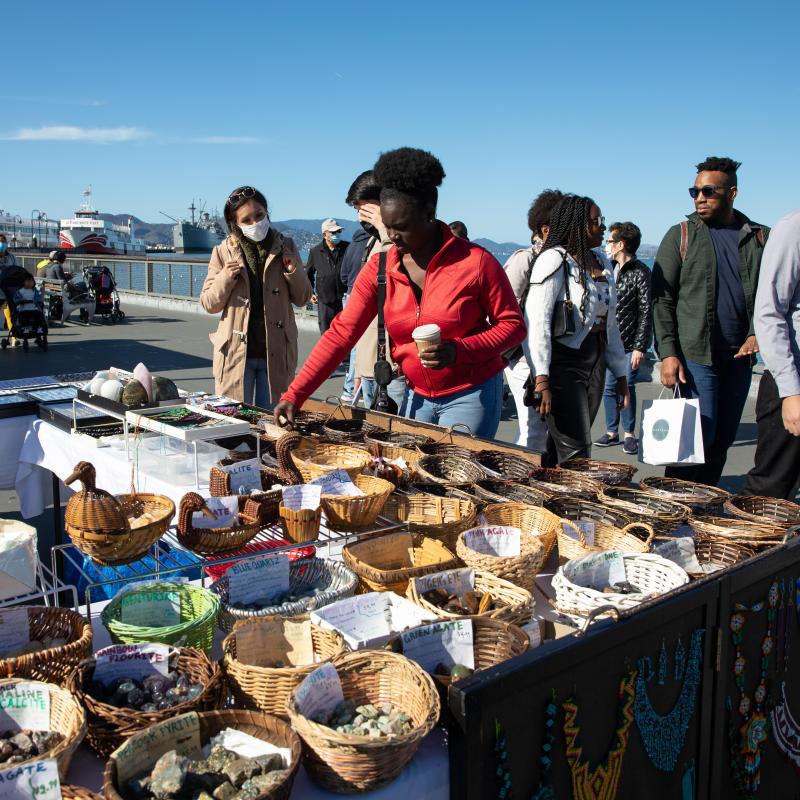 People shopping at a street vendor's table at Fisherman's Wharf